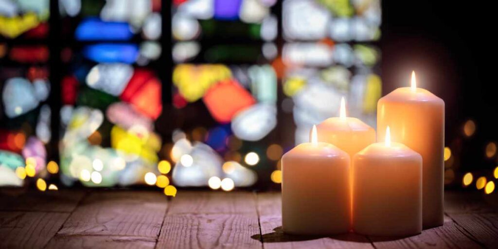 stained glass window with 4 lit candles