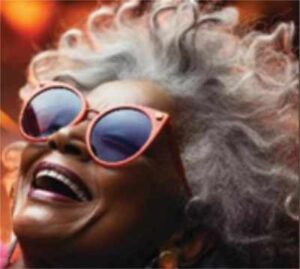 Happy woman with gray hair and sunglasses singing and promoting The People's Choir