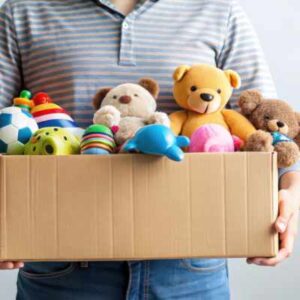 Man carrying donation of soft toys for charity